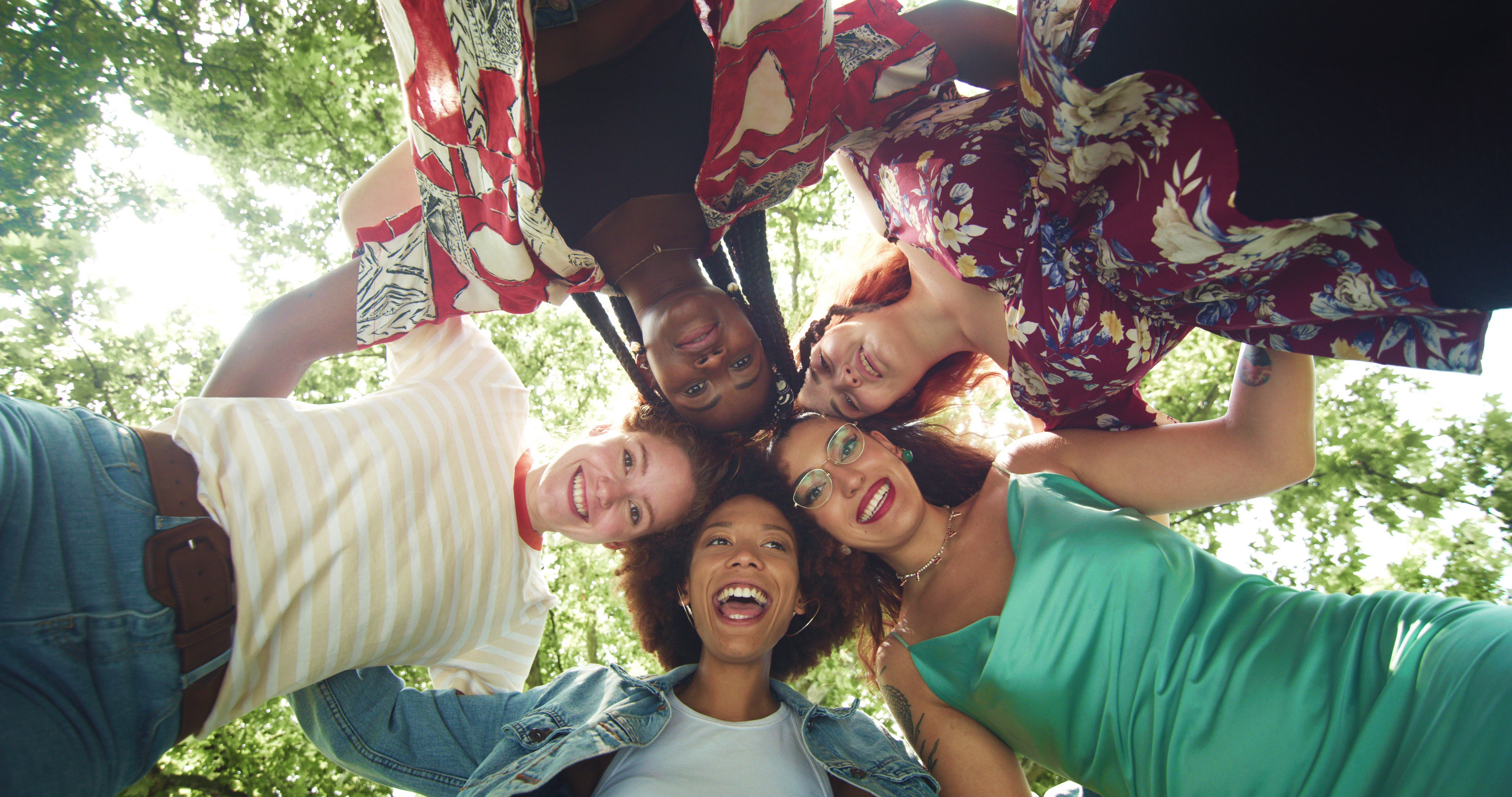 Four women in a circle looking down